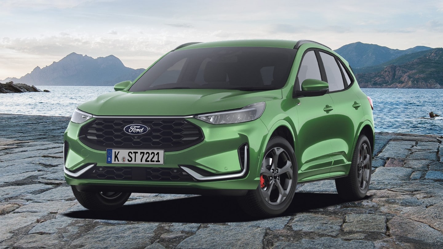 Un Ford Kuga vert, le SUV best-seller de Ford, est garé sur un sol de pierres. Au fond, on distingue un plan d’eau et des montagnes.