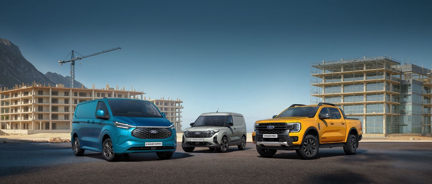 Un Ford E-Transit Custom, un Ford E-Transit Courier et un Ford Ranger PHEV stationnés sur une route. Un Ford E-Transit Custom, un Ford E-Transit Courier et un Ford Ranger PHEV stationnés sur une route.