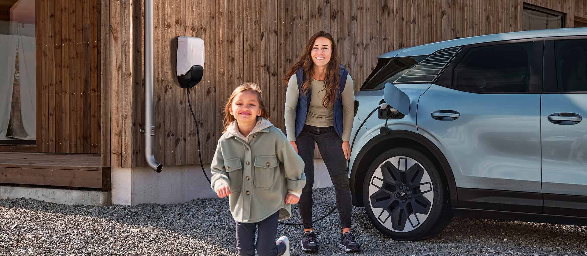 Une famille recharge son Ford Explorer électrique sur une borne de recharge en s’amusant.