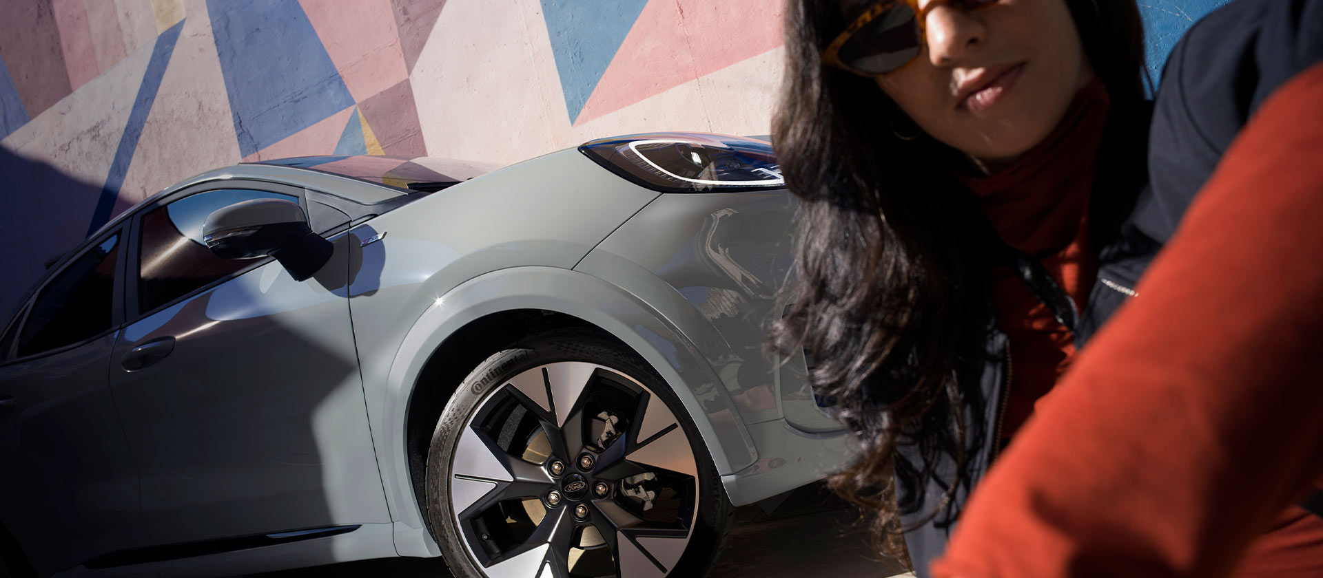 Une personne est assise à côté d’un Ford Puma Mild Hybrid.