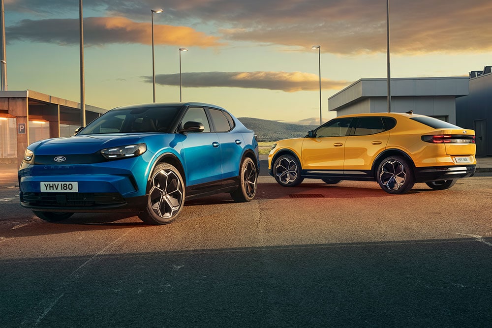 Deux Ford Capri® entièrement électriques, l’une jaune et l’autre bleue, sont parquées ensemble dans une rue.