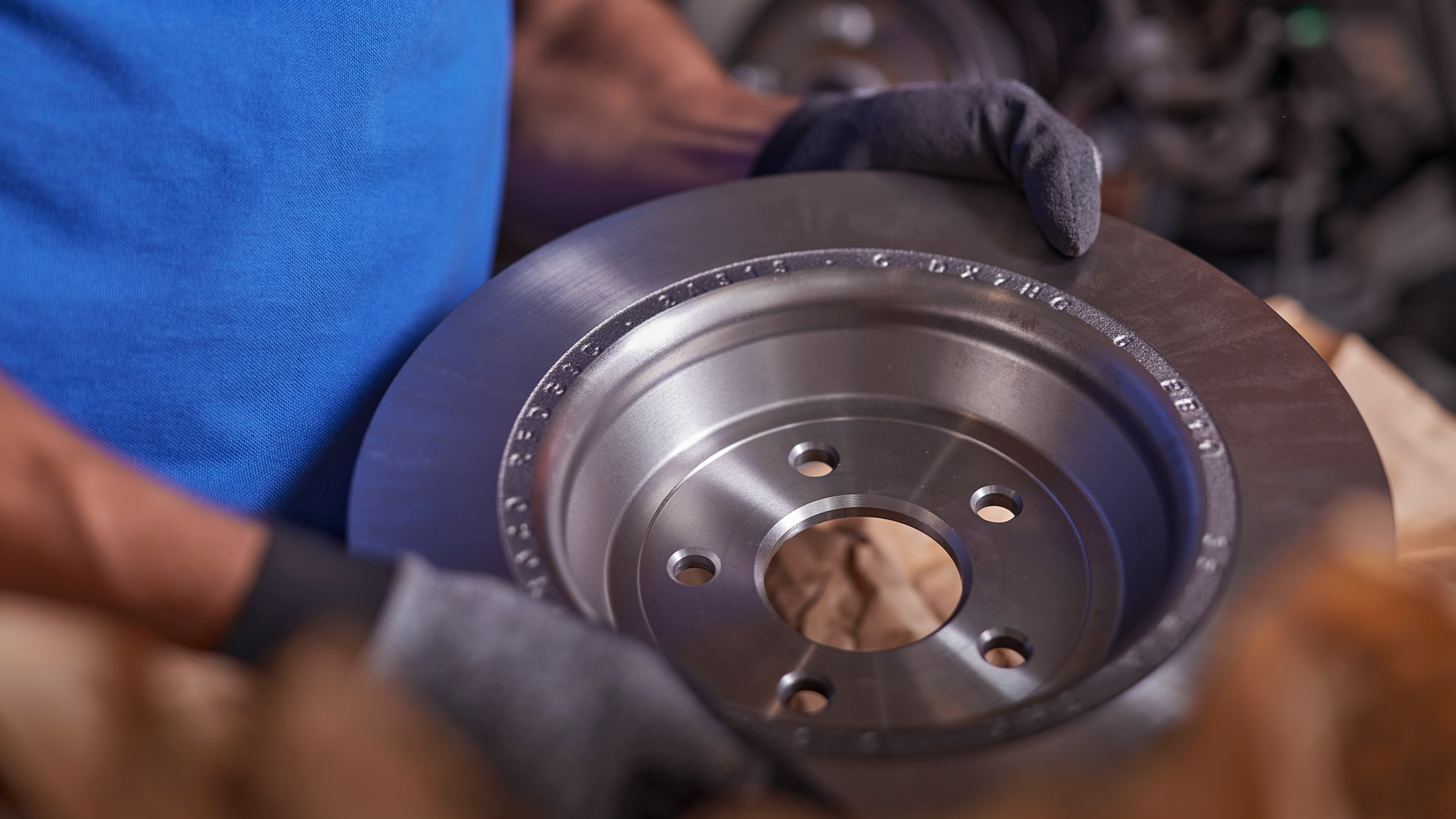 Un mécanicien Ford tient un disque de frein d’origine Ford.